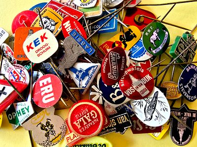 A collection of vintage lapel pins, mostly made of metal (Tchotchkes) from various brands, from 
