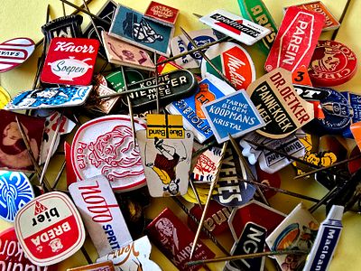 A collection of vintage lapel pins, mostly made of metal (Tchotchkes) from various brands, from 