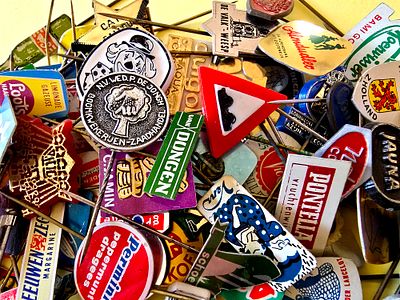 A collection of vintage lapel pins, mostly made of metal (Tchotchkes) from various brands, from 