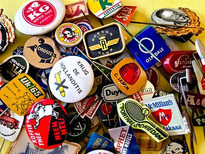 A collection of vintage lapel pins, mostly made of metal (Tchotchkes) from various brands, from 