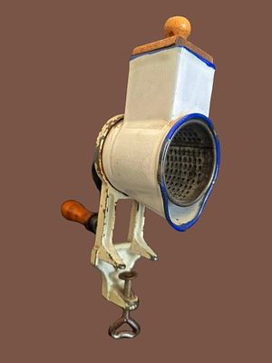 An antique, hand-operated cast metal food grater (also known as a grinder or almond and cheese 