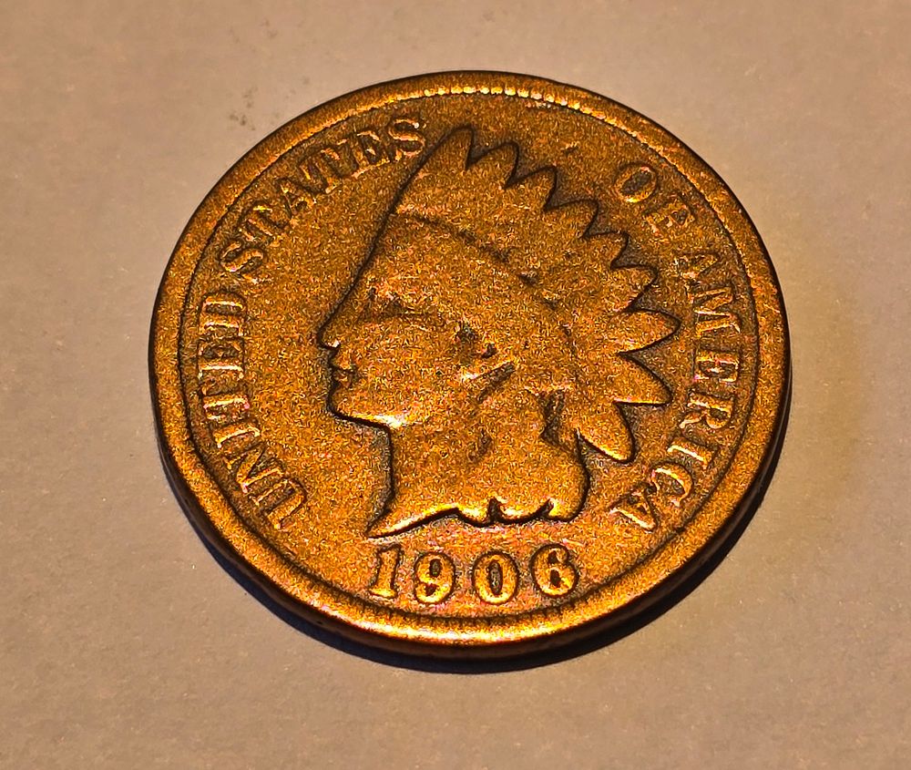 American "Indian Head Cent" coin from 1906. The coin depicts the image of "Liberty" wearing a 