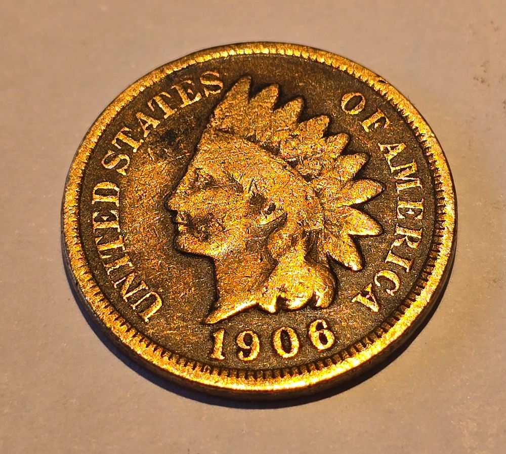 American "Indian Head Cent" coin from 1906. The coin depicts the image of "Liberty" wearing a 