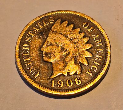 American "Indian Head Cent" coin from 1906. The coin depicts the image of "Liberty" wearing a 