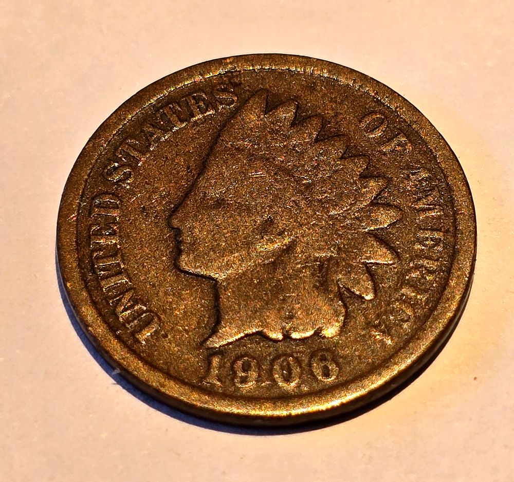 American "Indian Head Cent" coin from 1906. The coin depicts the image of "Liberty" wearing a 