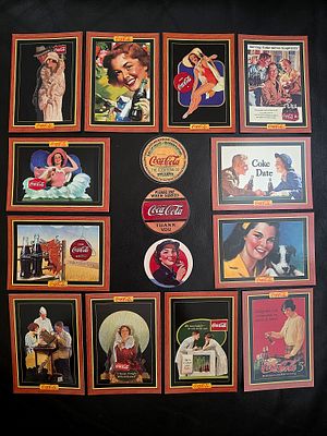 A collection of Coca-Cola cards and mugs. The cards and wrappers represent advertising scenes 
