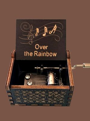 A wooden music box with a manual mechanism that plays the song "Somewhere Over the Rainbow". Mech 