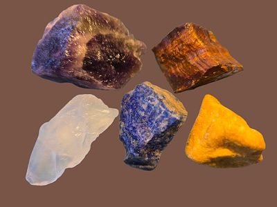 A collection of raw, unprocessed gemstones. The stones are natural, not polished or processed 