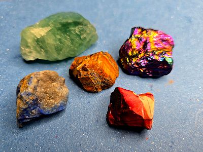 A collection of raw, unprocessed gemstones. The stones are natural, not polished or processed 