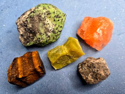 A collection of raw, unprocessed gemstones. The stones are natural, not polished or processed 