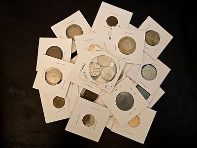 A collection of vintage coins from various countries. Coins are packaged in cardboard coin 
