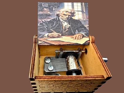 A miniature music box with a manual mechanical mechanism plays a scene suggestive of the 