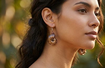 A pair of earrings made of natural ammonite fossils wrapped in copper wire. The net height of 