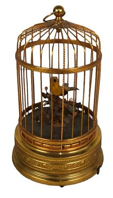 Singing Mechanical Bird In Cage. A singing mechanical bird in a gilt cage in working condition 