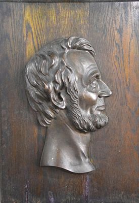 Bronze Lincoln. A bronze profile of Abraham Lincoln plaque mounted on a walnut board by Victor 