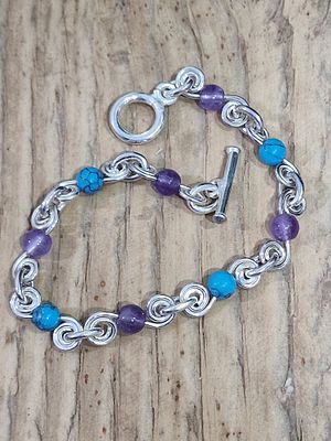 צמיד שרשרת כסף סטרלינג כולל חוליות עגולות משובצות באמטיסט סגול וטורקיז כחול.
מידה 20 ס"מ
16 גרם