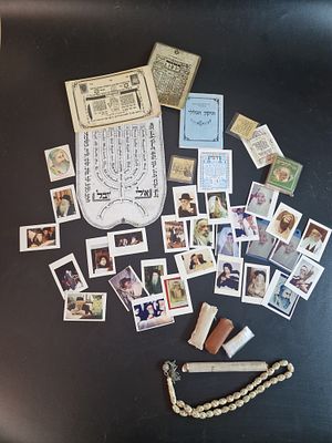 לוט קמעות.
הלוט כולל קמעות תמונות צדיקים, שוויתי נראה בכתב יד, מזוזה.