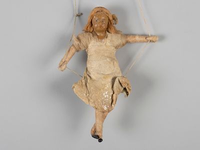 Елочная игрушка Девочка на качелях. 1930-1950-е. Вата, папье-маше, роспись. Высота 9,3 см. 