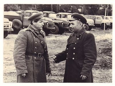 Два офицера СА на фоне автомобилей. Послевоенная фотография. Размеры 14,5х20,0 см. Имеются 