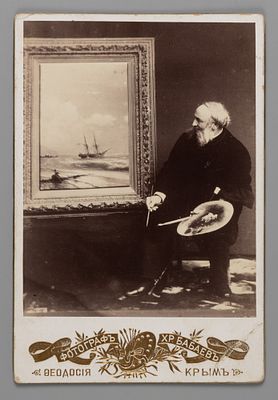 Кабинетная фотография Ивана Айвазовского на фоне собственной работы. Фотография Хр. Бабаева. 