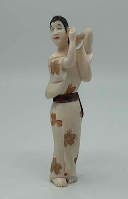 Нэцкэ "Девушка, расчесывающая волосы". ХХв. Слоновая кость. Подпись мастера. Размер: 7,5x2см.