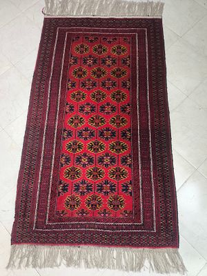 שטיח ראנר אדום בעבודת יד בעיצוב אפגני מסורתי עם דוגמאות גיאומטריות (כגון דגם "רגל הפיל") 