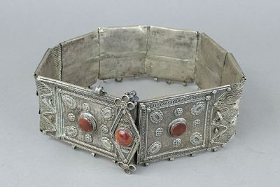 חגורת כסף תימנית עתיקה מורכבת מתשע חוליות כבדות מחוברות ביניהן באריגת חוטי כסף ומשובצות באבני 