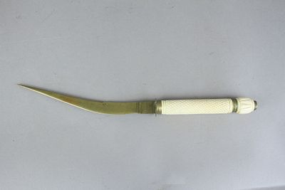 סכין דקורטיבית עם להב ארוך מפליז וידית לבנה מחומר תרמוסטי או מעצם. מיועדת לקישוט או לפתיחת 