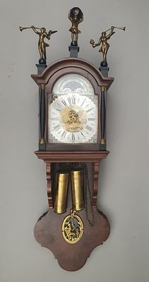 שעון קיר ארופאי ישן עם פיגורות פליז ועיטורים רבים.