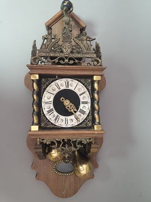 שעון קיר ארופאי ישן עם פיגורות פליז ועיטורים רבים.