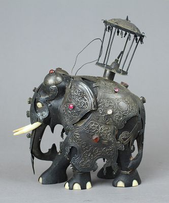 פסלון פיל מלחמה מעץ הבנה (Ebony) מעוטר שריון לחימה מכסף מרוקע ומשובץ באבנים טובות חצי יקרות. 