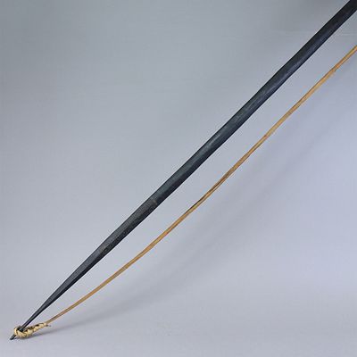 קשת ארוכה מפפואה ניו גוינאה עשויה מעץ דקל מקומי הידוע בשם דקל שחור, בחתך משולש, מעוטר באחד 