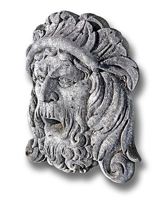 A CARVED LIMESTONE WALL FOUNTAIN MASK, SECOND HALF 20TH CENTURY. In the form of a crowned 