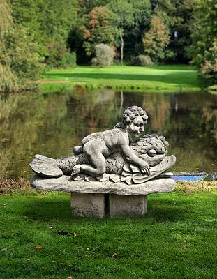 A SCULPTED LIMESTONE FIGURAL FOUNTAIN, LATE 20TH CENTURY. The putto modelled nude with legs 