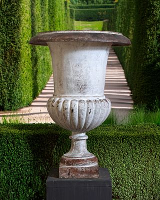 A LARGE CAST IRON GARDEN URN, 19TH CENTURY. Of Campana shape, the everted rim above a tapering 