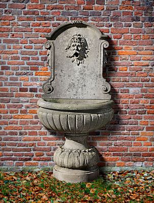 A CONTINENTAL SCULPTED LIMESTONE WALL FOUNTAIN, 20TH CENTURY. The arched reserve panel carved 
