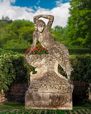 A COMPOSITION STONE PLANTER, MID 20TH CENTURY. Modelled with a partially draped maiden perched 
