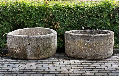 TWO SIMILAR CIRCULAR CARVED LIMESTONE TROUGHS, 18TH OR 19TH CENTURY. The larger: Height 40 cm. 