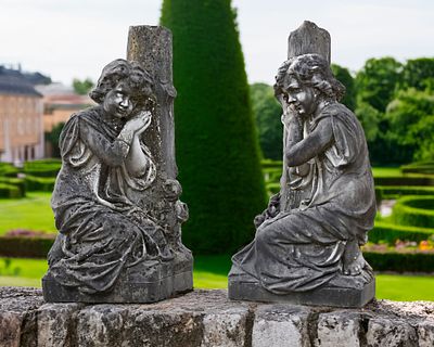 A PAIR OF CARVED WHITE MARBLE KNEELING CHILDREN AGAINST A TREE TRUNK BY F. BUSELL, FRENCH, LATE 