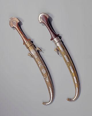 A PAIR OF SILVER DAGGER, MOROCCO, 19TH CENTURY. With a curved blade, wooden hilt, and scabbard 