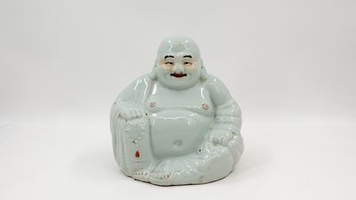A Chinese blanc de chine porcelain figure of seated buddha. Resting with a necklace in his 