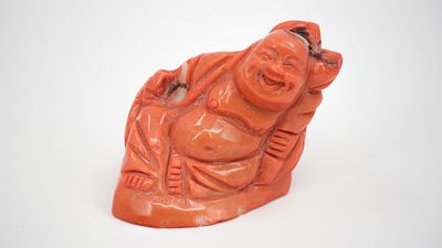 A Chinese red coral miniature sculpture of a laughing seated Buddha. 20th century. H: 4,7 cm