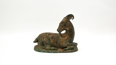 A Tibetan patinated bronze figurine sculpture of a resting goat. First half 20th century. H: 21,5 cm