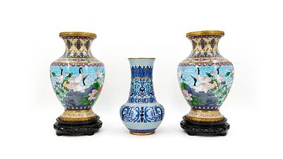 A lot of three Chinese cloisonne various decorated vases. Two vases on a wooden base. 20th 
