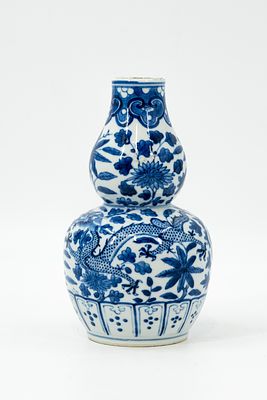 A Chinese blue and white decorated double gourd shaped porcelain vase. Decor of dragon in a 