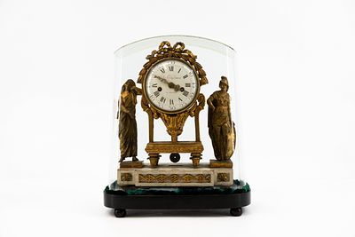 An antique French Louis XVI polychrome gilt carved wooden figural mantel clock. On a wooden 