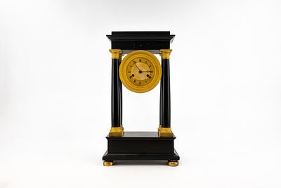 An antique Empire gilt bronze mounted black marble column mantel clock. Marked, J.M BINJE 