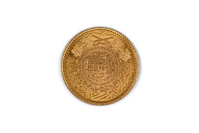 A Saudi Arabian gold one Guinea coin. With Arabic inscriptions and palm trees above crossed 