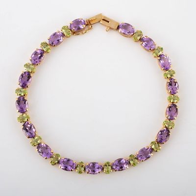 14K GOLD AMETHYST & PERIDOT BRACELET. (17) .5 Carat +/- horizontal oval amethyst stones 