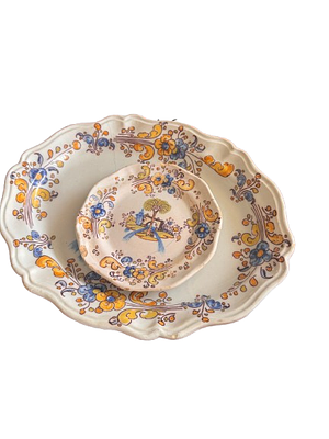 Oval Ceramic Plate. A smaller, circular plate, nestled within the larger platter. It shares the 